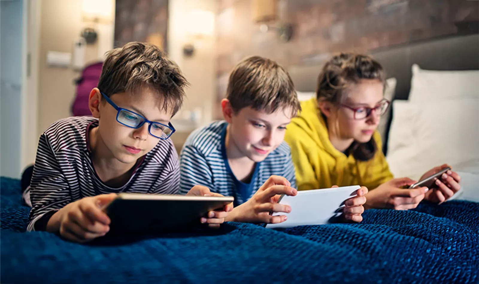 Siblings hang out while using multiple internet devices